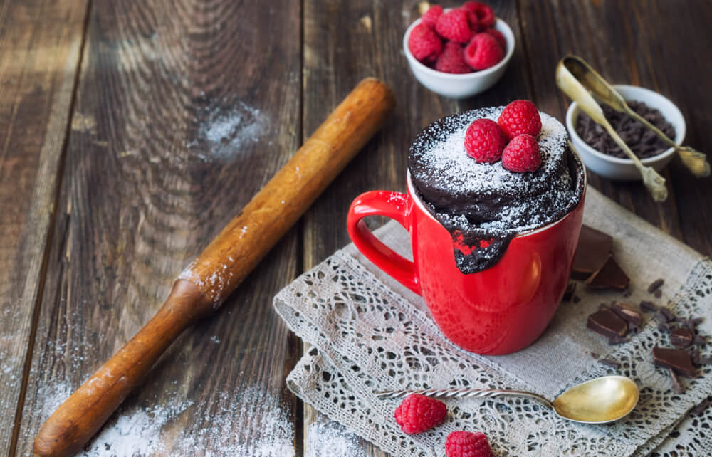 Čokoládový mug-cake s malinami v červenom hrnčeku